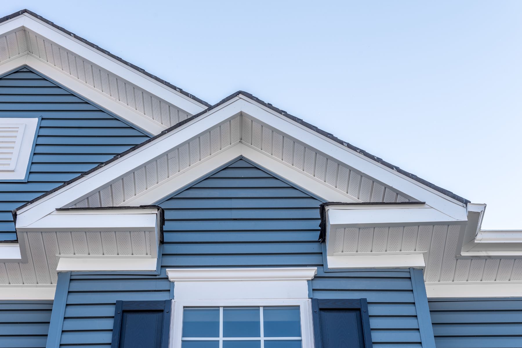 Blue and white residential house exterior with gabled roof and horizontal siding