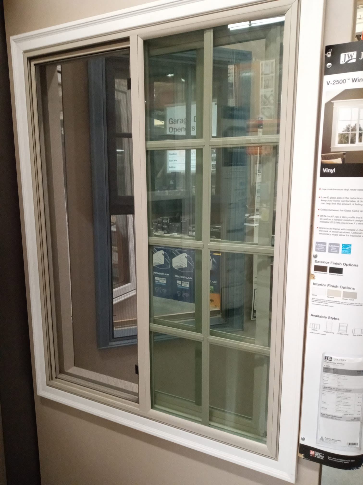 Sliding glass patio door with white frame displayed in showroom with product specifications